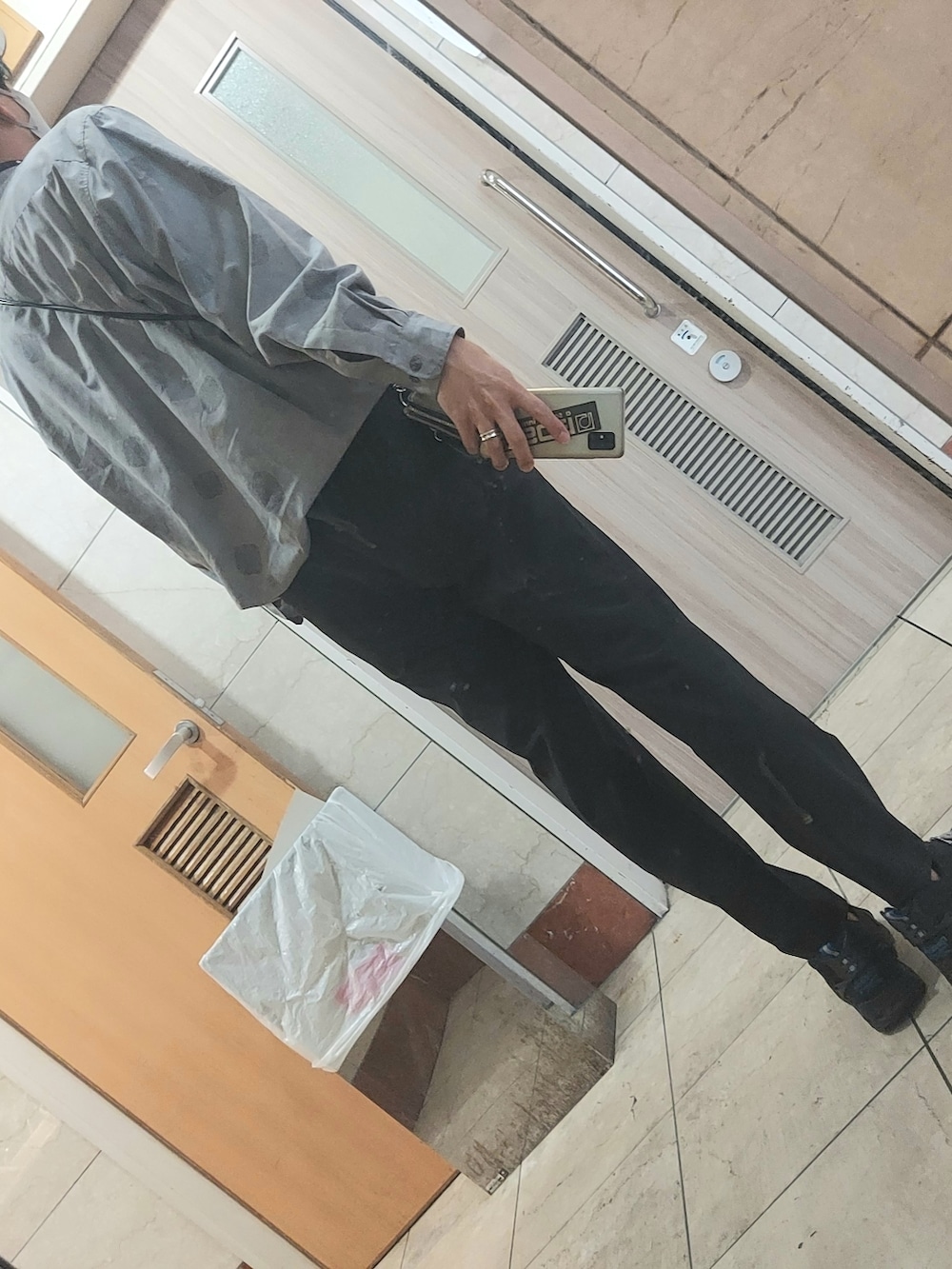 ブラック系のスニーカー、ブラック系のスラックス、ブラック系のショルダーバッグを着用したメンズの春コーディネートの2枚目の写真