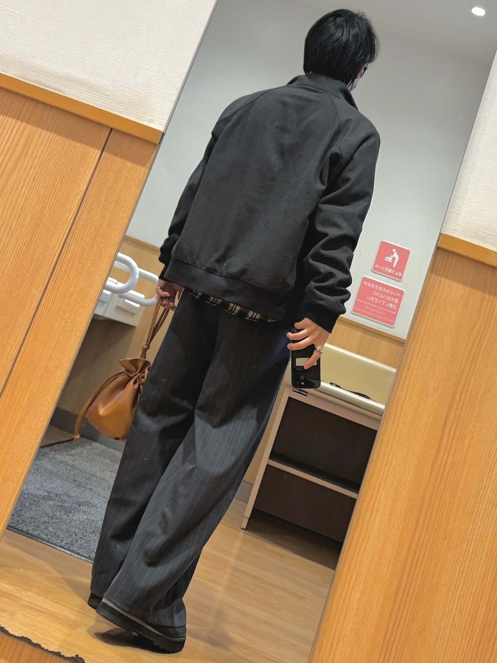 ブラック系のブルゾン、ブラウン系のスウェット、ブラウン系のショルダーバッグを着用したメンズの冬コーディネートの2枚目の写真