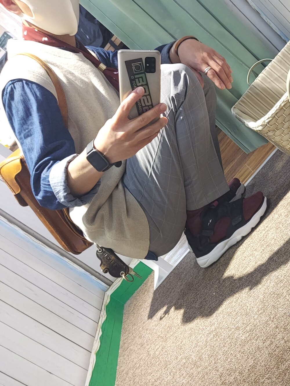 ブラック系のサンダル、グレー系のスラックス、ベージュ系のベストを着用したメンズの春コーディネートの4枚目の写真