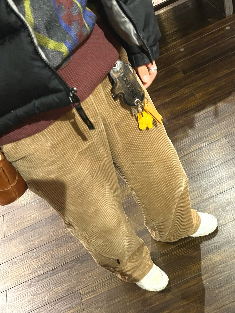 ブラウン系のパンツ、ホワイト系のスニーカー、ブラウン系のボディバッグ/ウエストポーチを着用したメンズの冬コーディネートの3枚目の写真