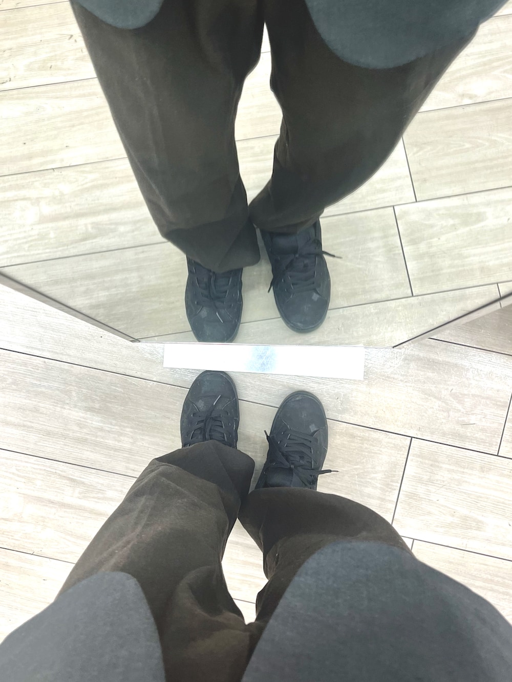 ブラック系のスニーカー、ブラウン系のスラックス、グレー系のテーラードジャケットを着用したメンズの冬コーディネートの4枚目の写真