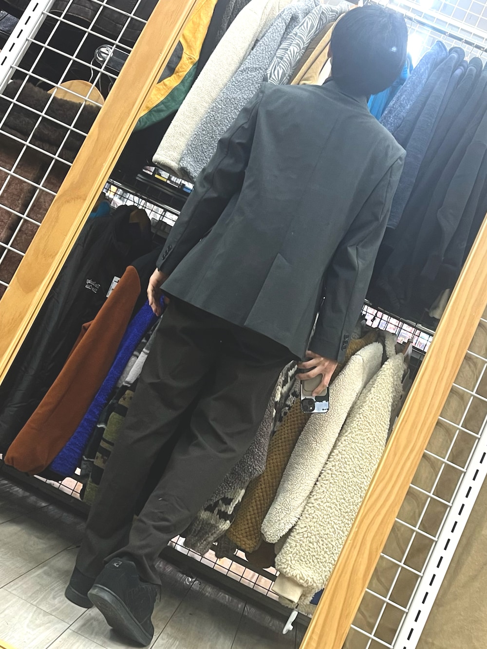 ブラック系のスニーカー、ブラウン系のスラックス、グレー系のテーラードジャケットを着用したメンズの冬コーディネートの2枚目の写真