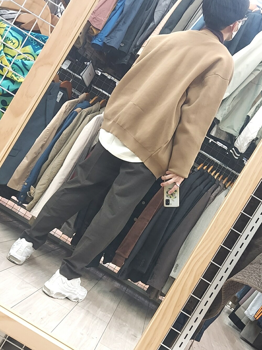 ブラウン系のパンツ、ホワイト系のスニーカー、ブラウン系のカーディガン/ボレロを着用したメンズの冬コーディネートの2枚目の写真