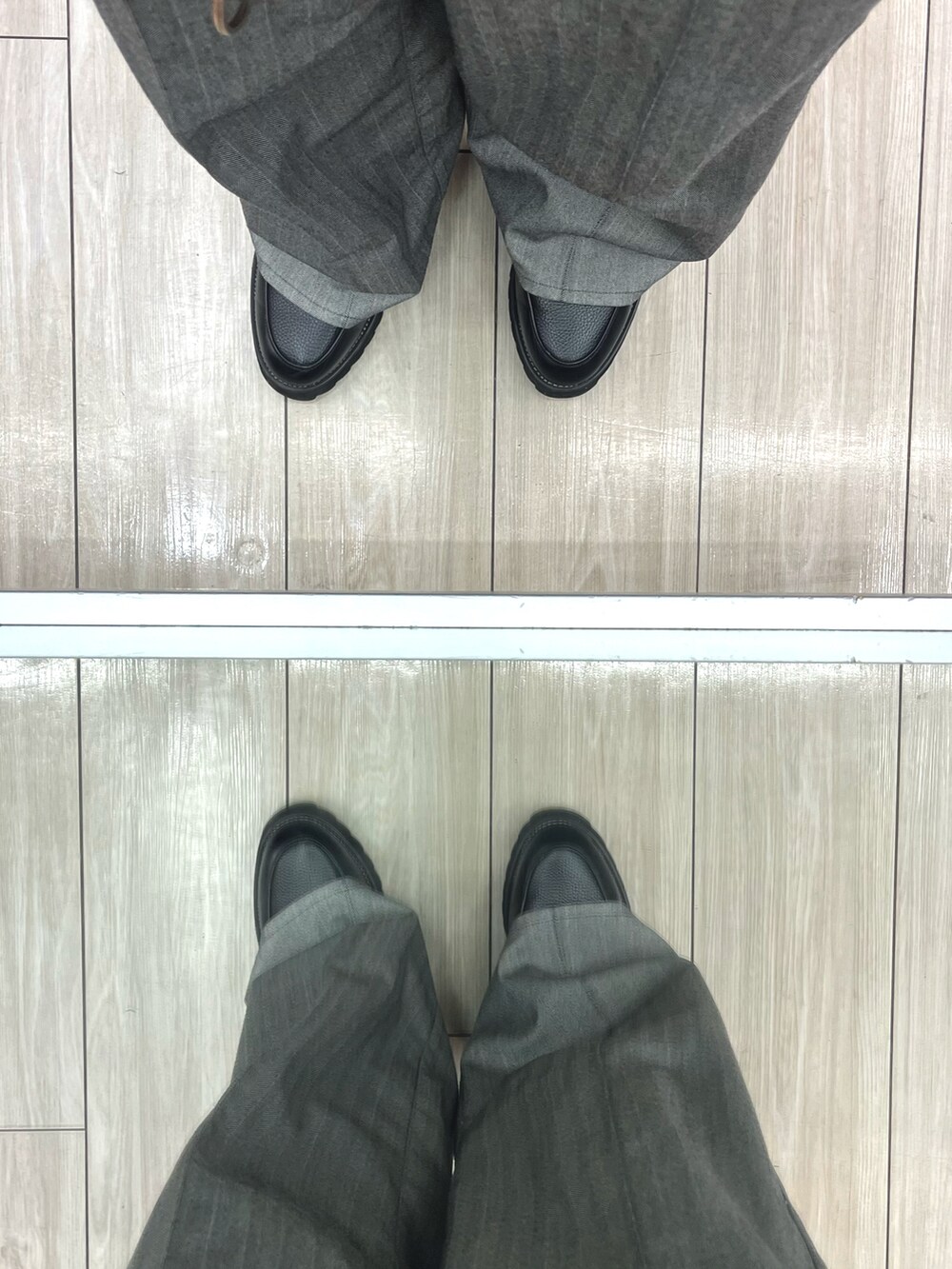 グレー系のスラックス、ブラック系のドレスシューズ、その他のニット/セーターを着用したメンズの春コーディネートの5枚目の写真