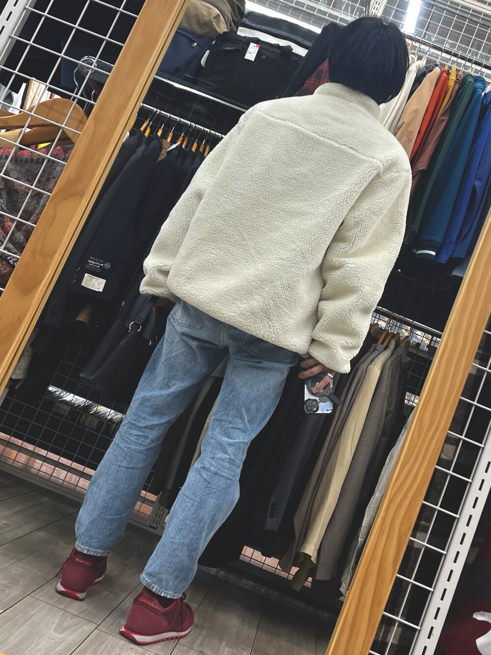 ブルー系のデニムパンツ、レッド系のスニーカー、ホワイト系のブルゾンを着用したメンズの春コーディネートの2枚目の写真