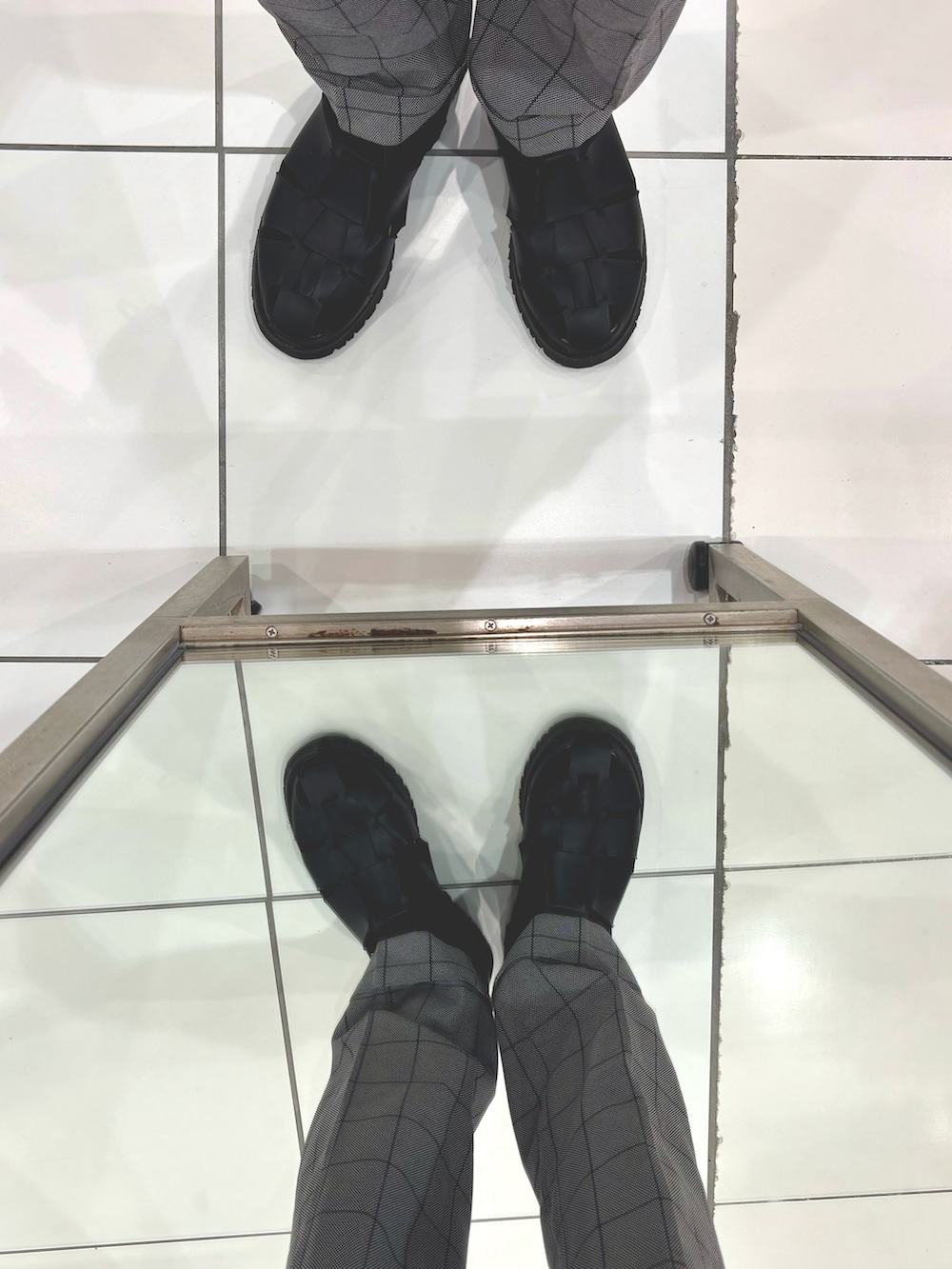 グレー系のスラックス、ブラック系のサンダル、ブラック系のボディバッグ/ウエストポーチを着用したメンズの夏コーディネートの5枚目の写真