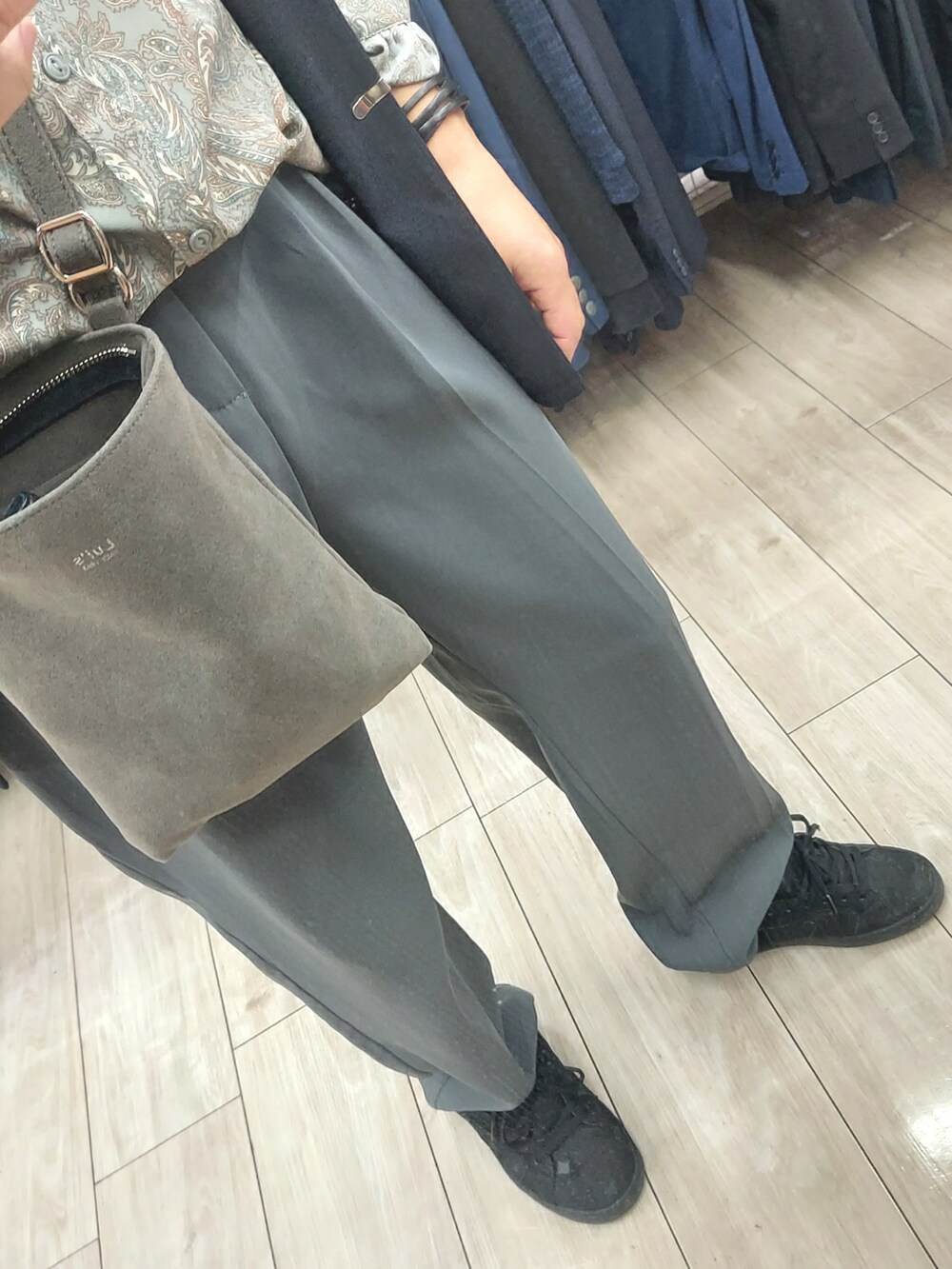 ブルー系のパンツ、ブラック系のスニーカー、グレー系のショルダーバッグを着用したメンズの春コーディネートの3枚目の写真