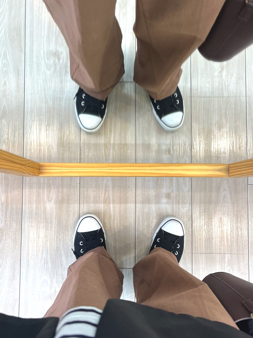 ブラウン系のハンドバッグ、ブラック系のテーラードジャケット、ホワイト系のTシャツ/カットソーを着用したメンズの春コーディネートの5枚目の写真