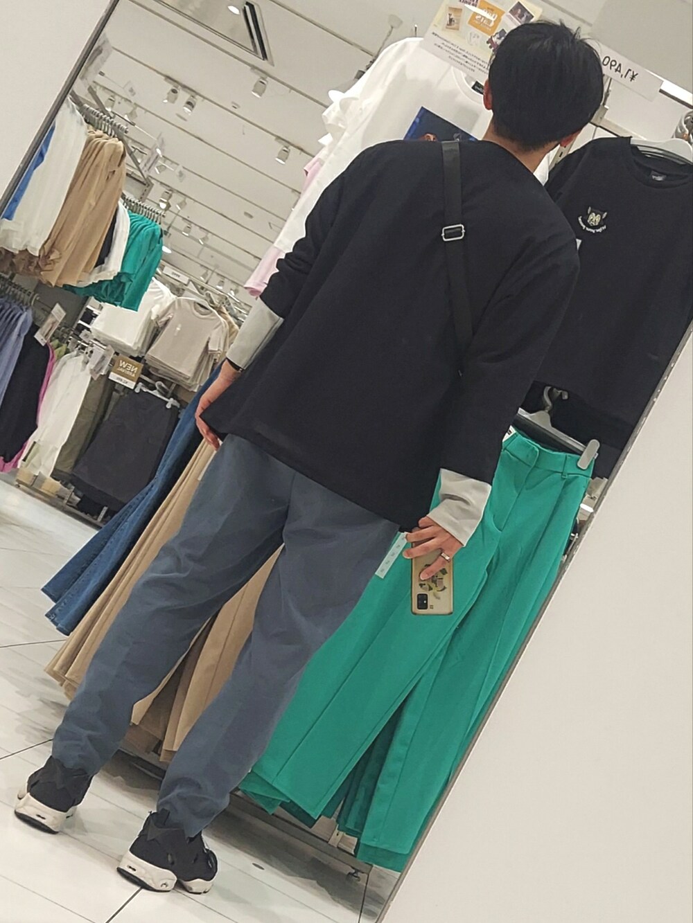 ブラック系のスニーカー、グリーン系のスラックス、グレー系のニット/セーターを着用したメンズの春コーディネートの2枚目の写真