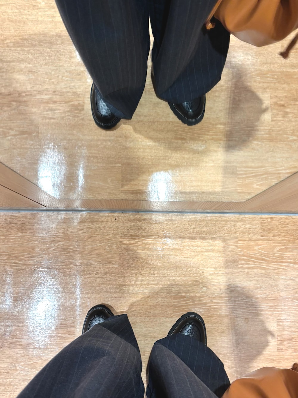 ブラック系のブルゾン、ブラウン系のスウェット、ブラウン系のショルダーバッグを着用したメンズの冬コーディネートの5枚目の写真