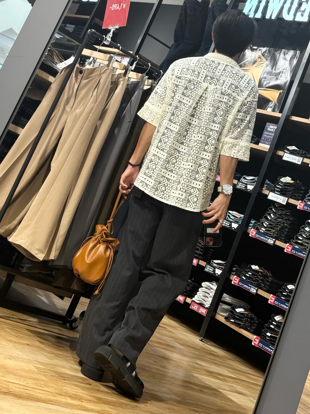 ブラウン系のショルダーバッグ、ブラック系のTシャツ/カットソー、ブルー系のその他パンツを着用したメンズの夏コーディネートの2枚目の写真