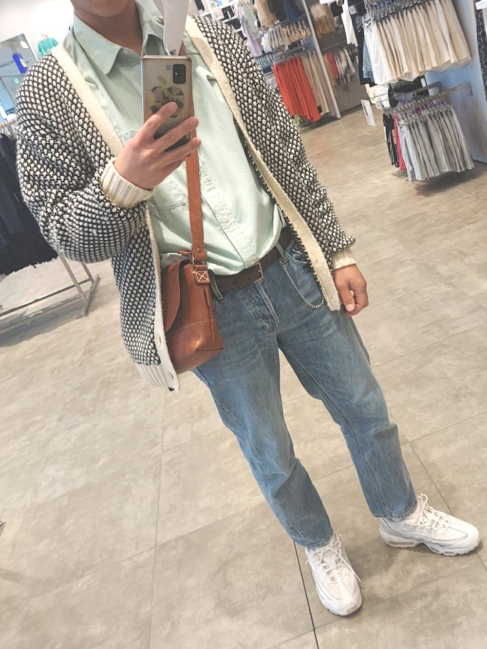 ブルー系のデニムパンツ、ホワイト系のスニーカー、ブラウン系のボディバッグ/ウエストポーチを着用したメンズの春コーディネートの5枚目の写真