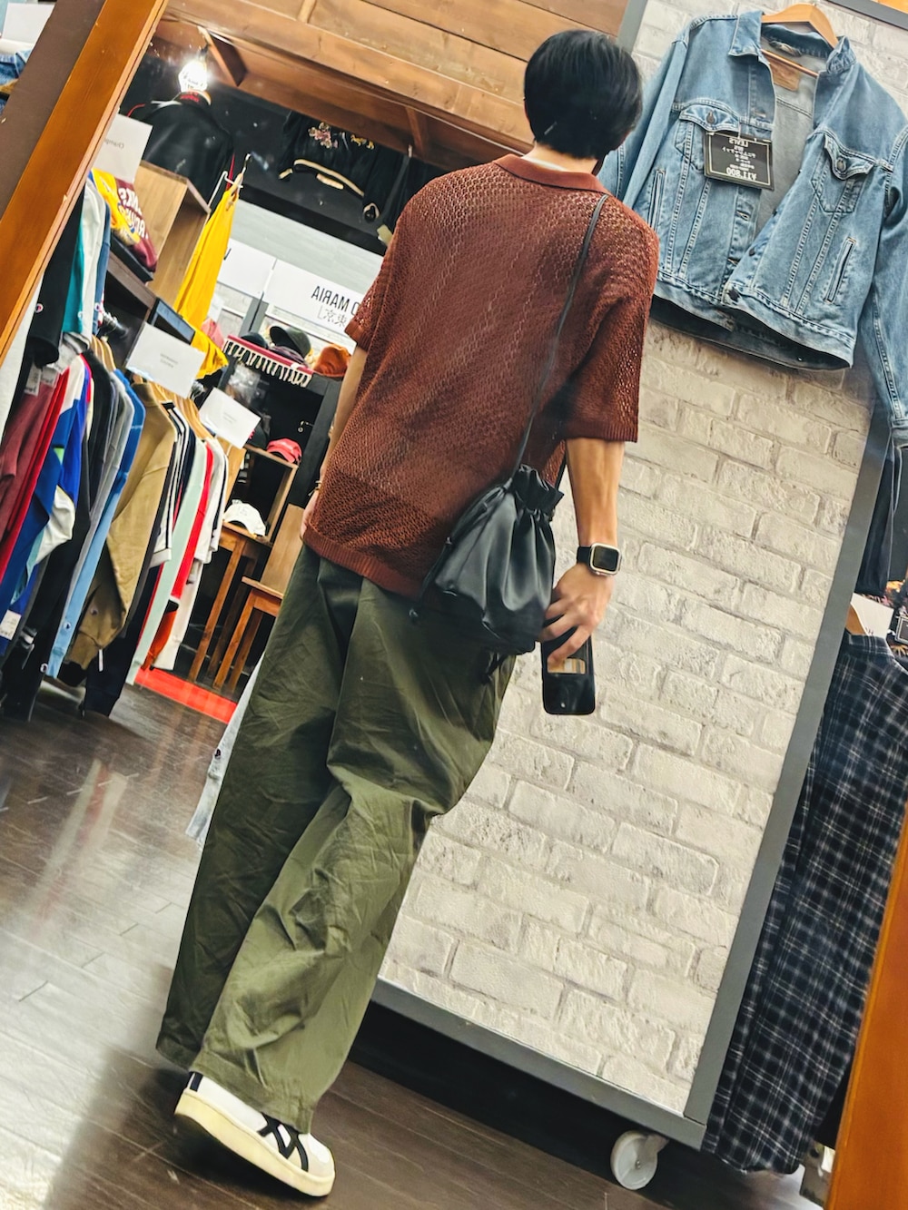 レッド系のポロシャツ、ホワイト系のスニーカー、グリーン系のパンツを着用したメンズの夏コーディネートの2枚目の写真