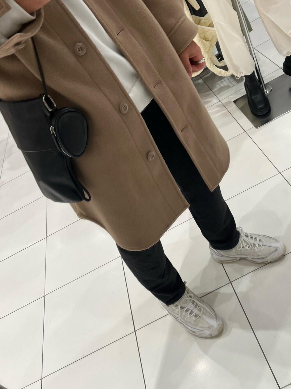 ブラック系のパンツ、ホワイト系のスニーカー、ベージュ系のムートンコートを着用したメンズの冬コーディネートの3枚目の写真