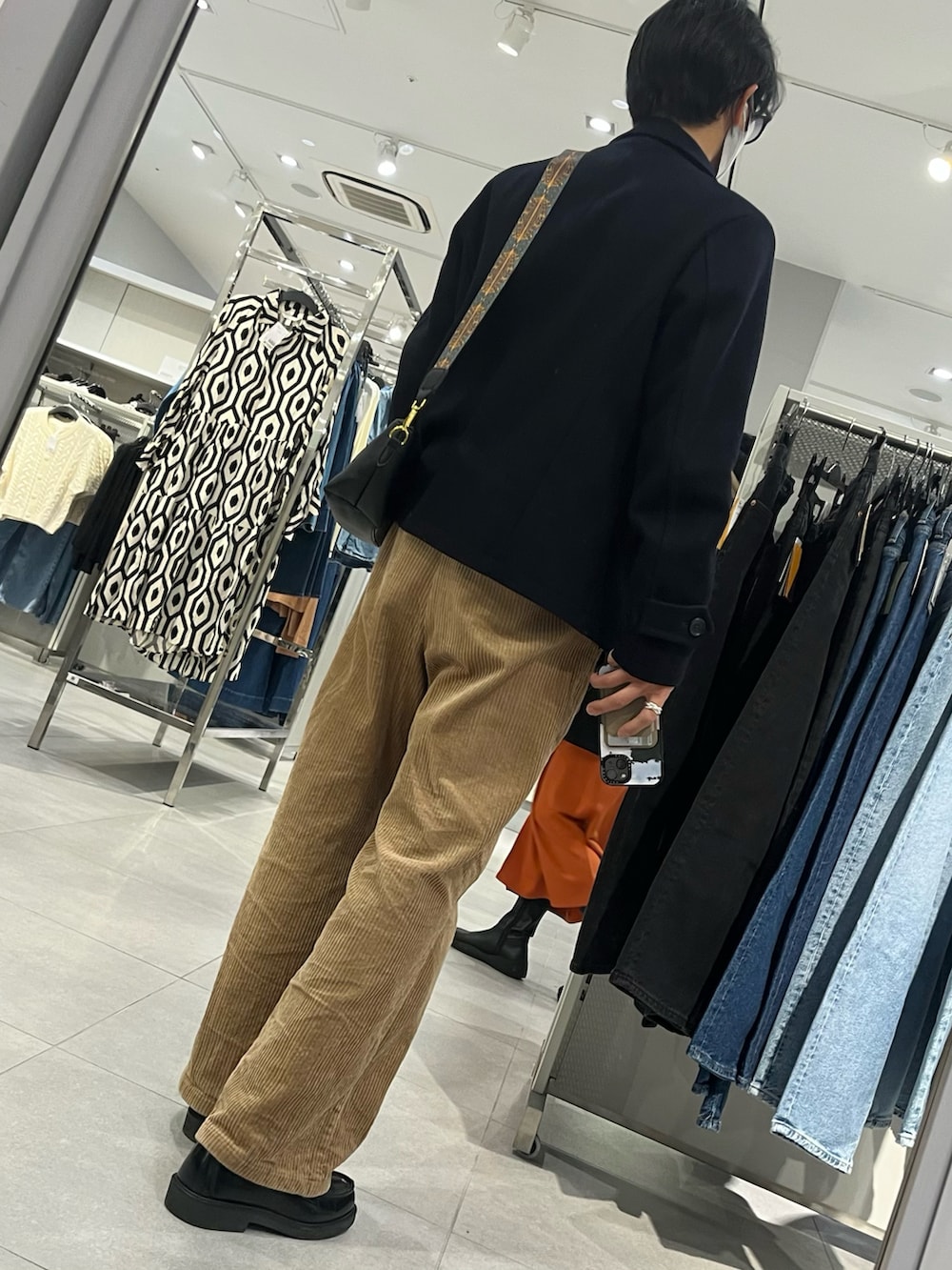 ブラウン系のパンツ、ブラック系のローファー、ブルー系のピーコートを着用したメンズの冬コーディネートの2枚目の写真