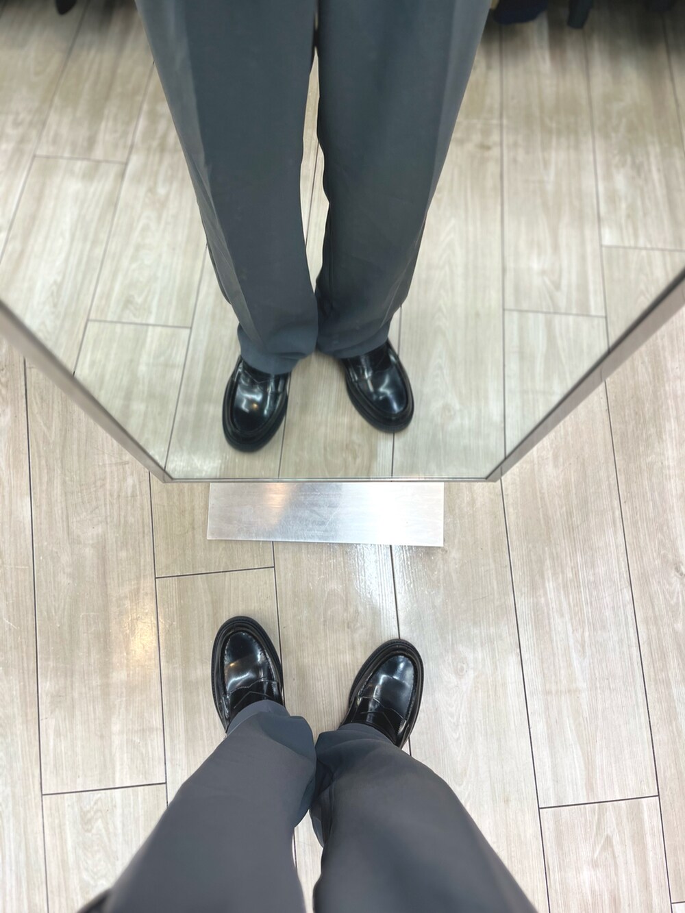 ブルー系のパンツ、ブラック系のローファー、ホワイト系のシャツ/ブラウスを着用したメンズの秋コーディネートの5枚目の写真