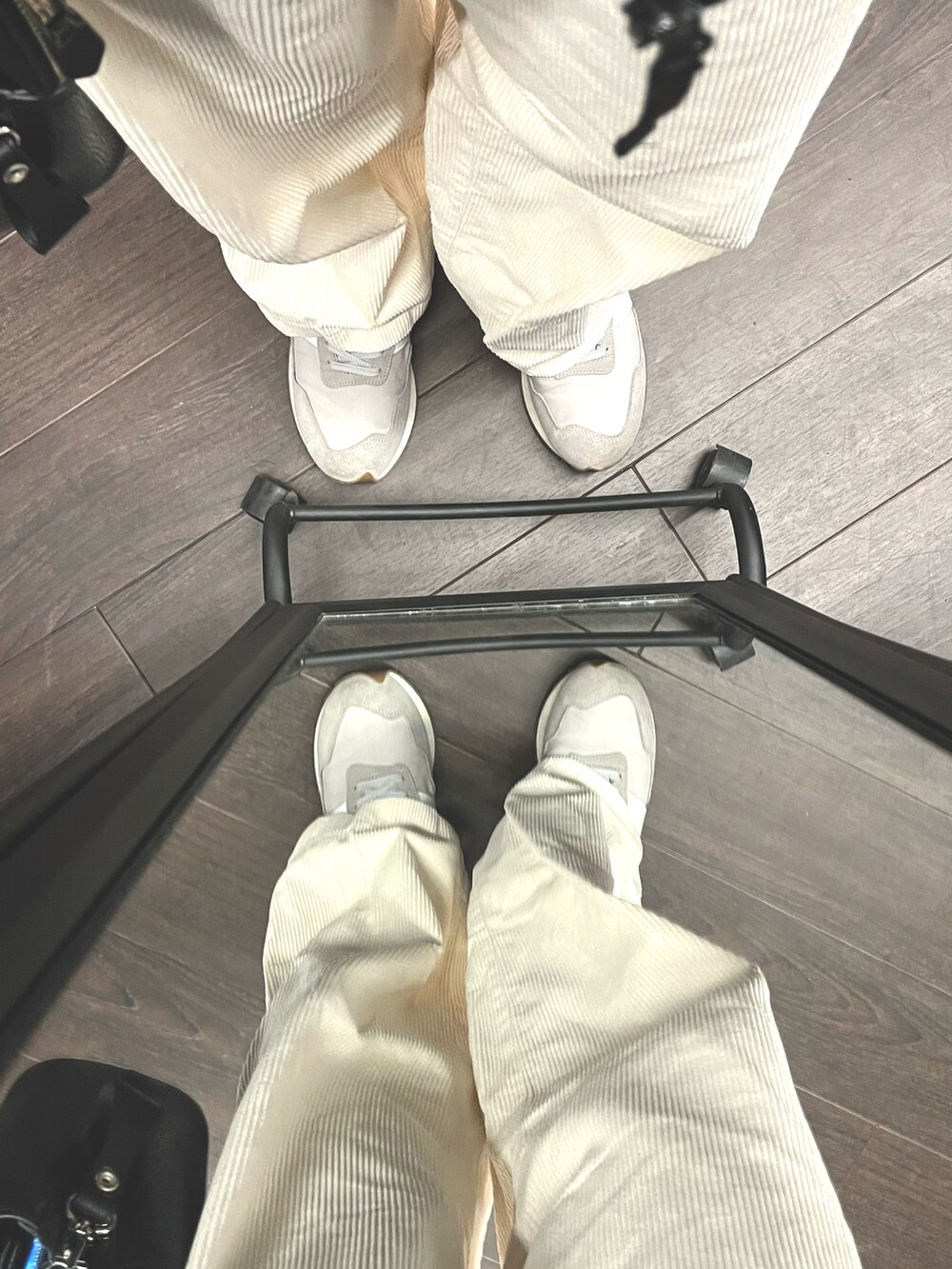 ホワイト系のパンツ、グレー系のスニーカー、ブラック系のショルダーバッグを着用したメンズの秋コーディネートの5枚目の写真