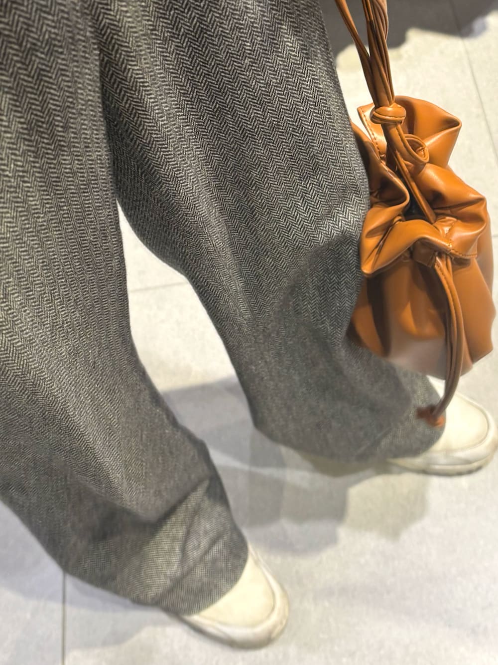 ブラウン系のショルダーバッグ、ホワイト系のスニーカー、ホワイト系のカーディガン/ボレロを着用したメンズの冬コーディネートの3枚目の写真