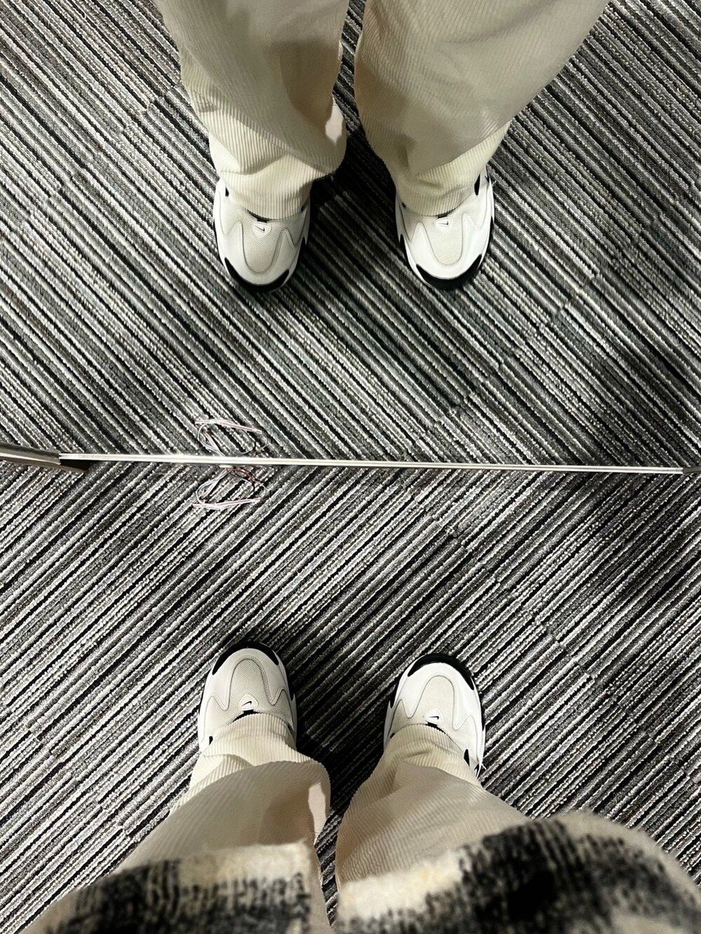 ホワイト系のスニーカー、ホワイト系のパンツ、ホワイト系のジャケット/アウターを着用したメンズの冬コーディネートの5枚目の写真