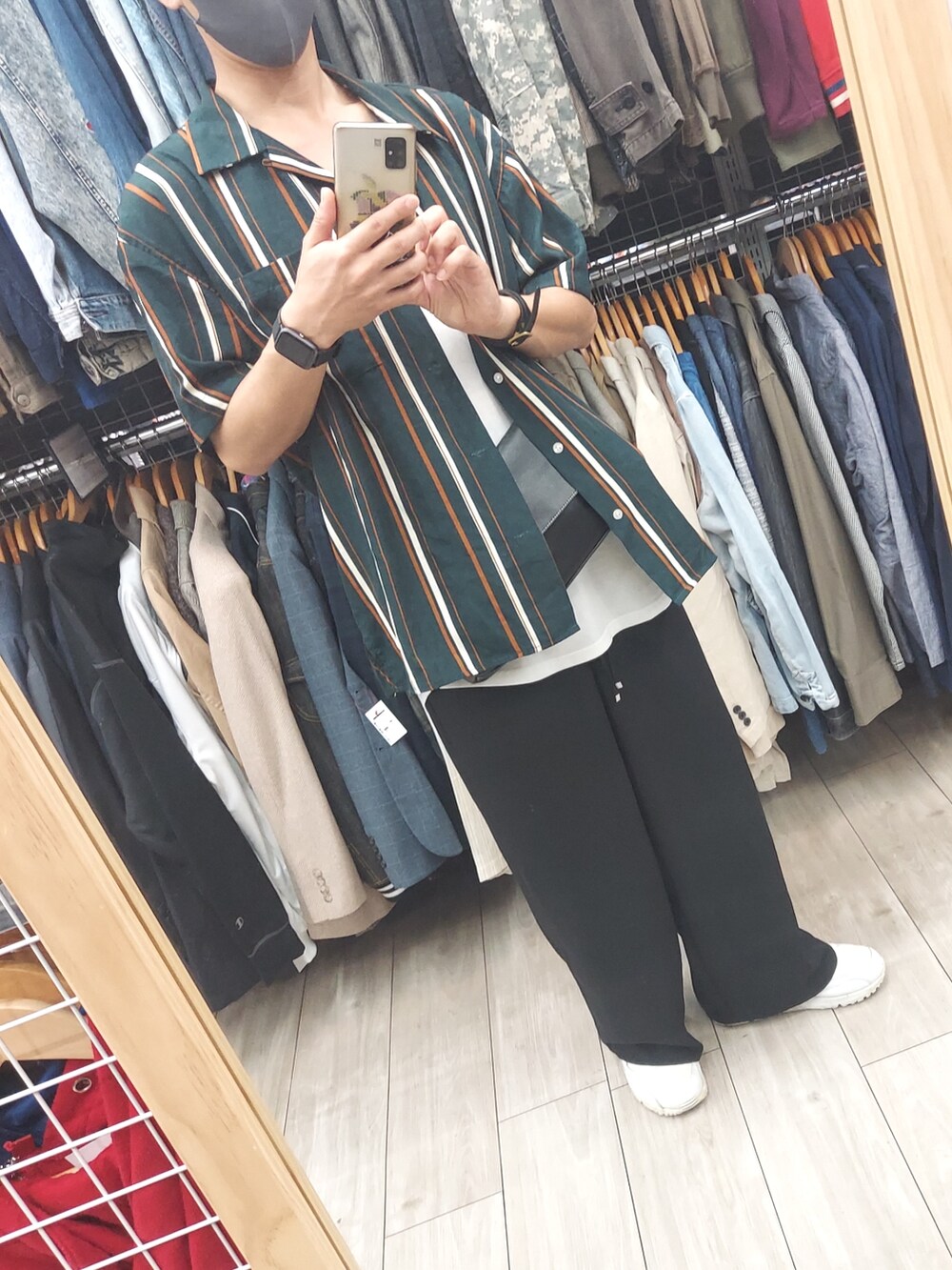 ブラック系のパンツ、ブラック系のバッグ、ホワイト系のタンクトップを着用したメンズの秋コーディネートの5枚目の写真