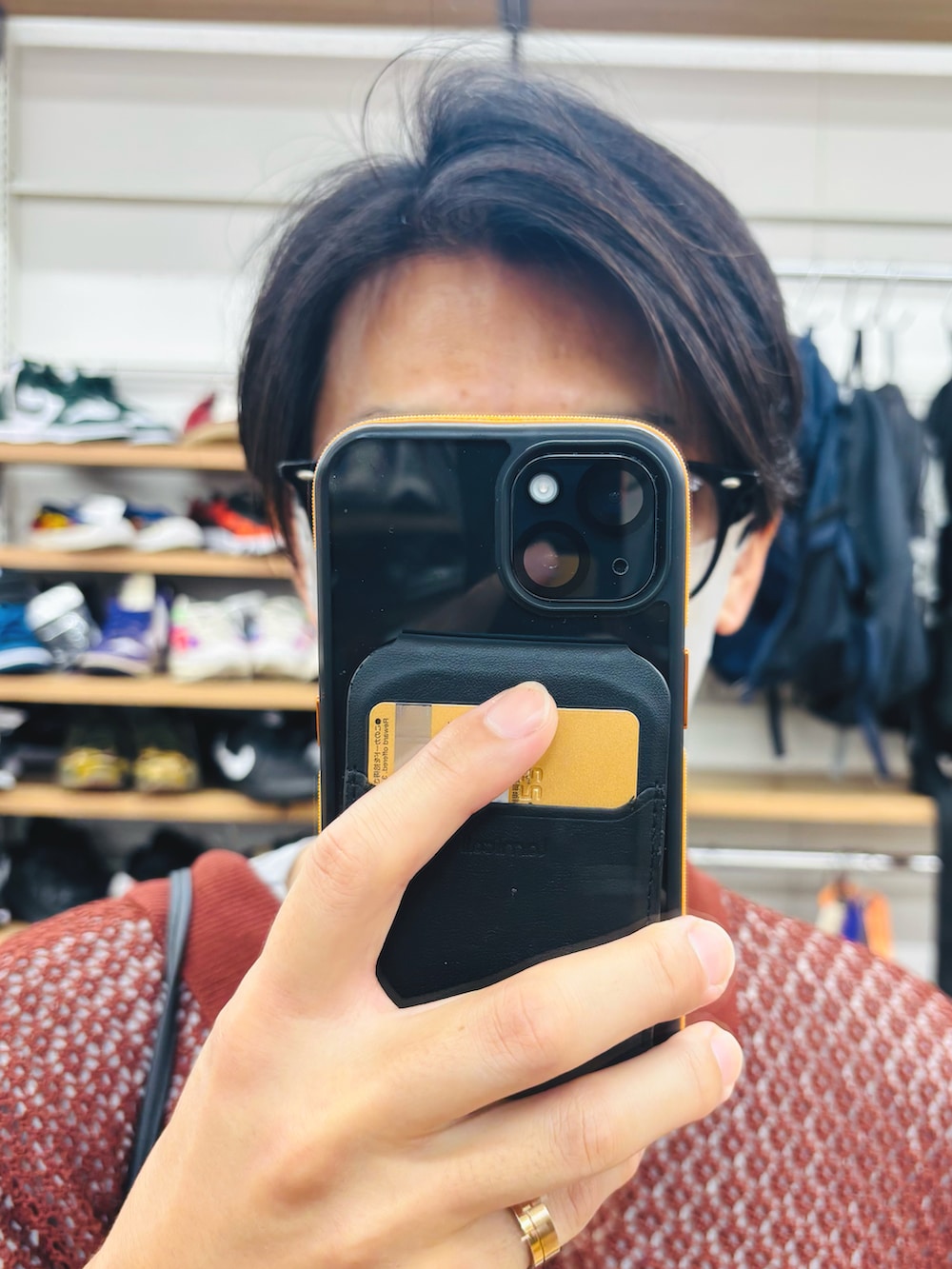 レッド系のポロシャツ、ホワイト系のスニーカー、グリーン系のパンツを着用したメンズの夏コーディネートの4枚目の写真