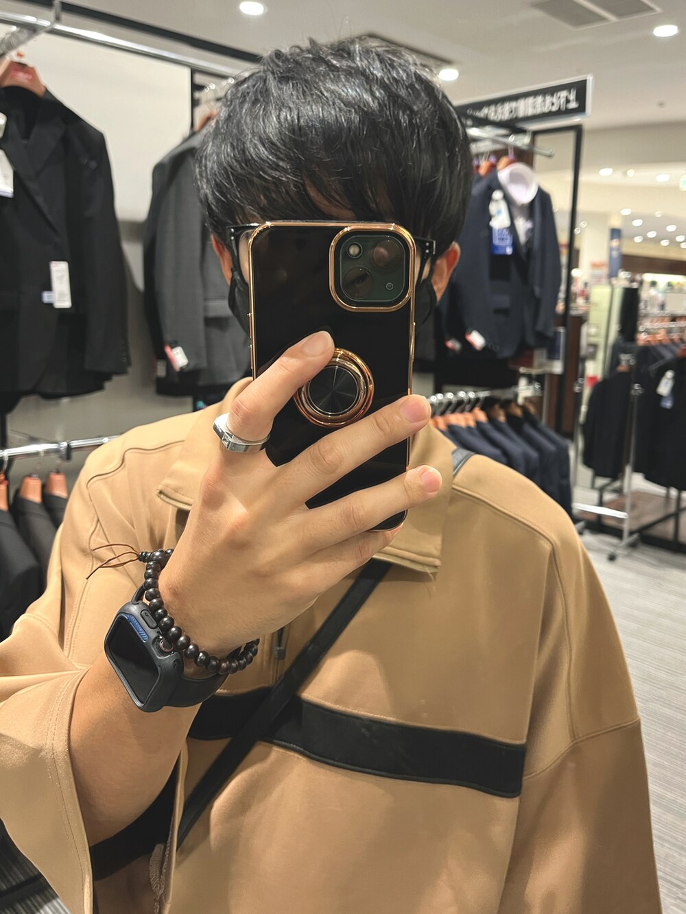 ブラック系のスニーカー、ブラック系のバッグ、ブルー系のデニムパンツを着用したメンズの秋コーディネートの4枚目の写真