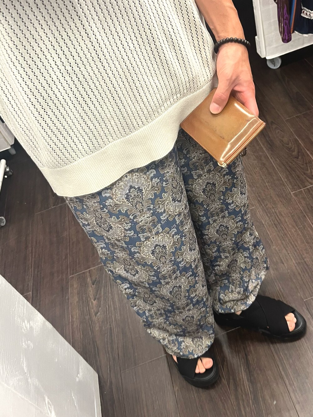 ブラック系のサンダル、ブルー系のパンツ、ベージュ系のベストを着用したメンズの秋コーディネートの3枚目の写真