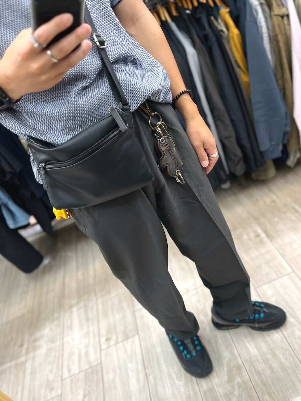 ブラック系のパンツ、ブラック系のスニーカー、ブルー系のポロシャツを着用したメンズの秋コーディネートの3枚目の写真