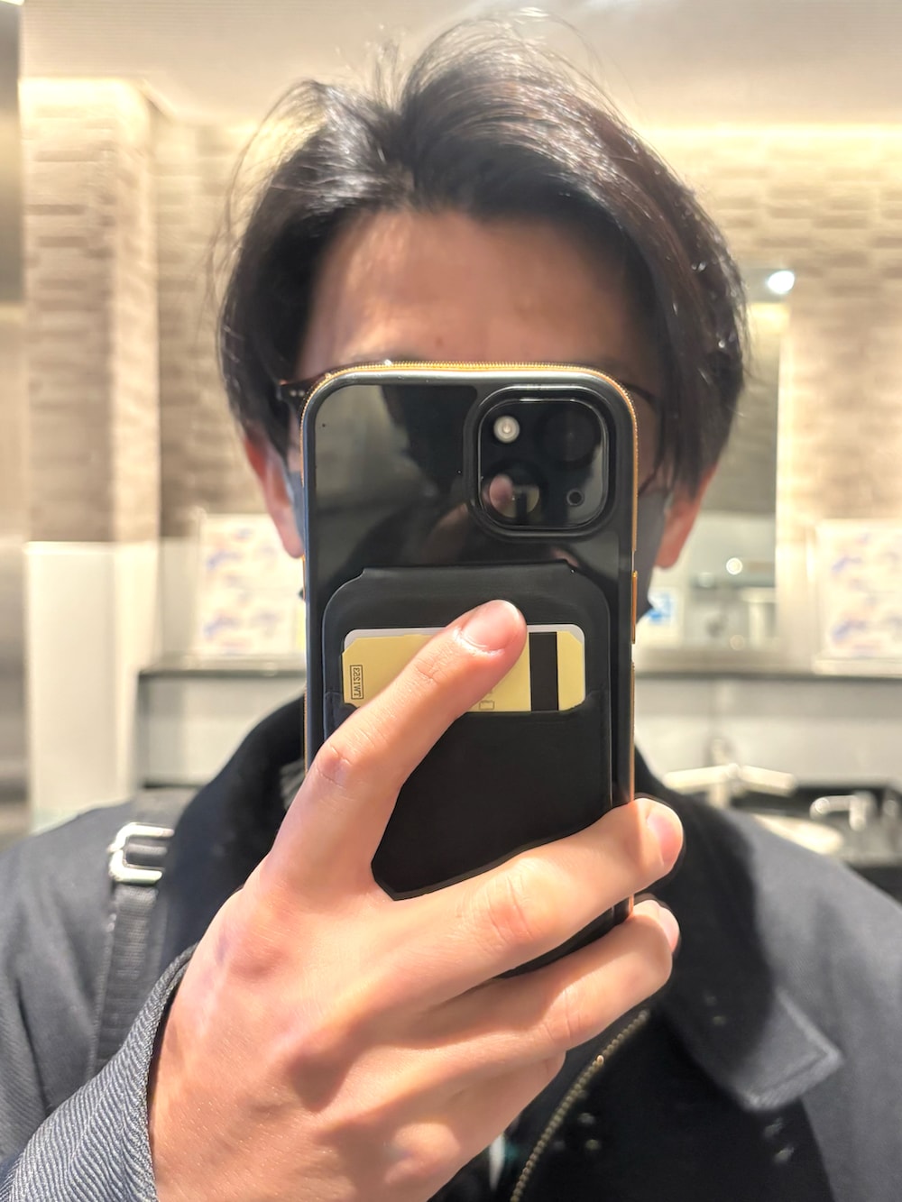 グレー系のスラックス、その他のビジネスシャツ、ブラック系のブルゾンを着用したメンズの春コーディネートの4枚目の写真