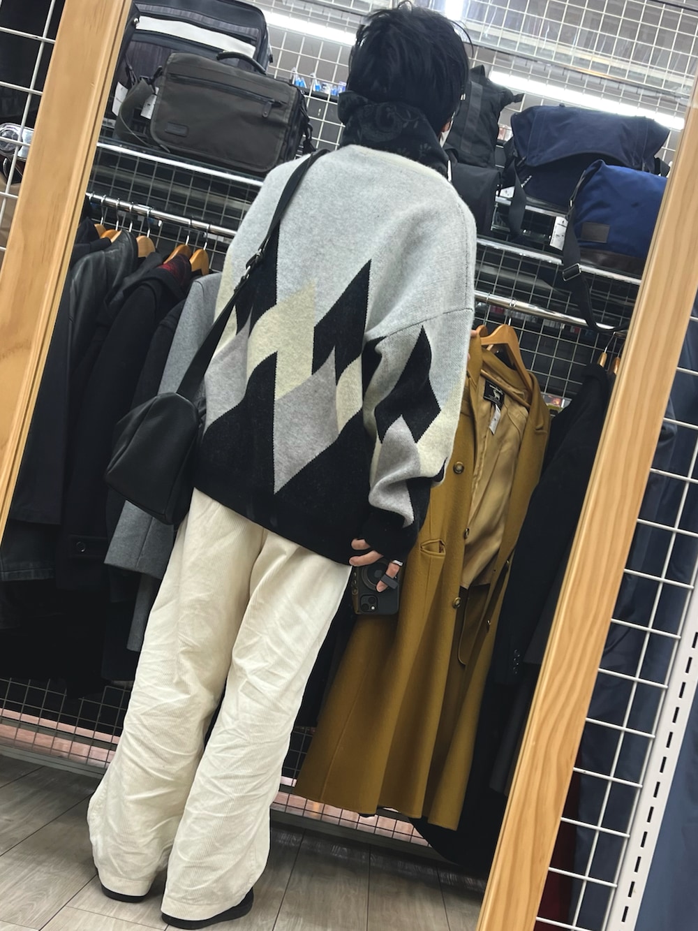 ホワイト系のパンツ、ブラック系のスニーカー、ホワイト系のニット/セーターを着用したメンズの冬コーディネートの2枚目の写真