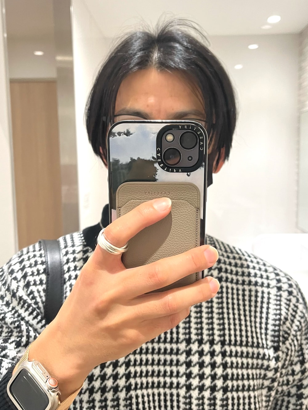 ブラック系のドレスシューズ、ブラック系のスラックス、ホワイト系のニット/セーターを着用したメンズの冬コーディネートの4枚目の写真