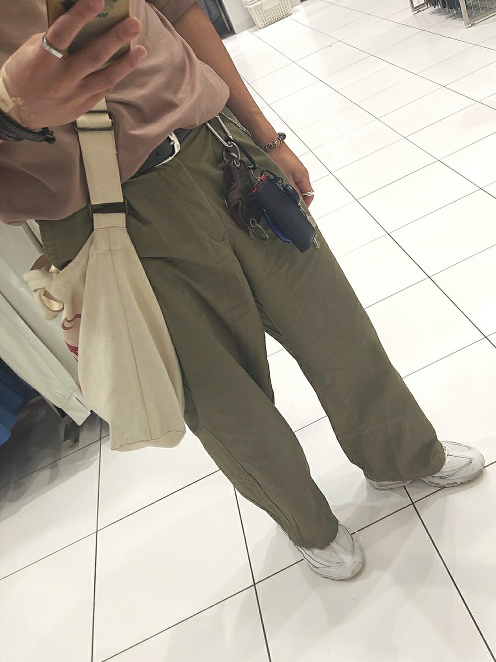 グリーン系のパンツ、ホワイト系のスニーカー、ベージュ系のバッグを着用したメンズの夏コーディネートの3枚目の写真