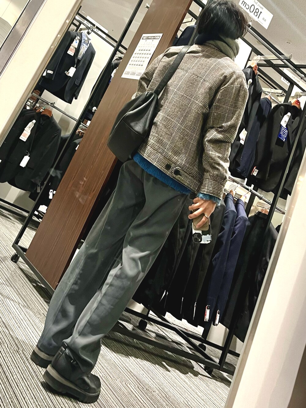 ブラック系のドレスシューズ、グレー系のスラックス、ブルー系のニット/セーターを着用したメンズの冬コーディネートの2枚目の写真