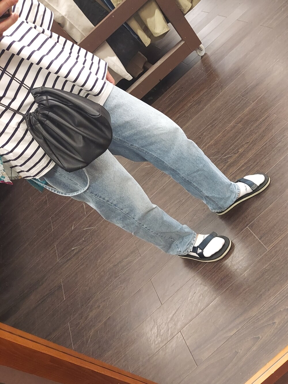 ブルー系のデニムパンツ、ホワイト系のTシャツ/カットソー、ブラック系のサンダルを着用したメンズの夏コーディネートの3枚目の写真
