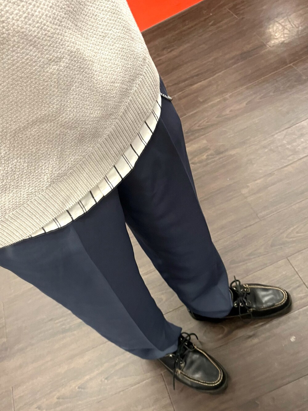 ブルー系のスラックス、ブラック系のローファー、ブラック系のショルダーバッグを着用したメンズの春コーディネートの3枚目の写真