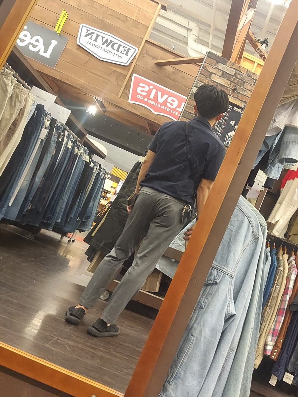 ブラック系のサンダル、グレー系のパンツ、ブルー系のビジネスシャツを着用したメンズの夏コーディネートの2枚目の写真