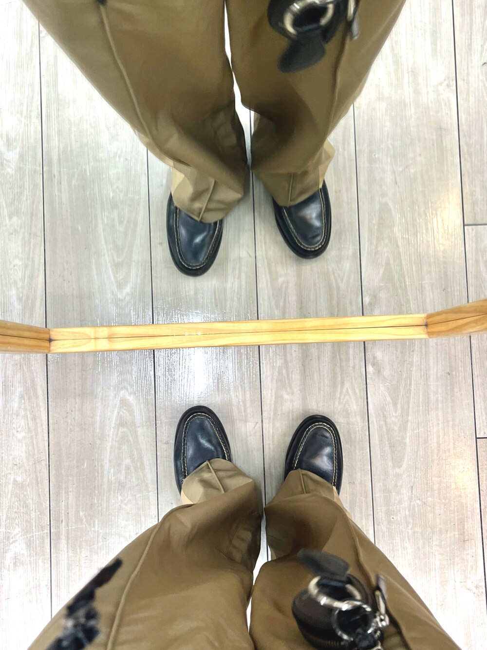 ブラック系のダウンジャケット/コート、ブルー系のニット/セーター、ベージュ系のパンツを着用したメンズの冬コーディネートの5枚目の写真