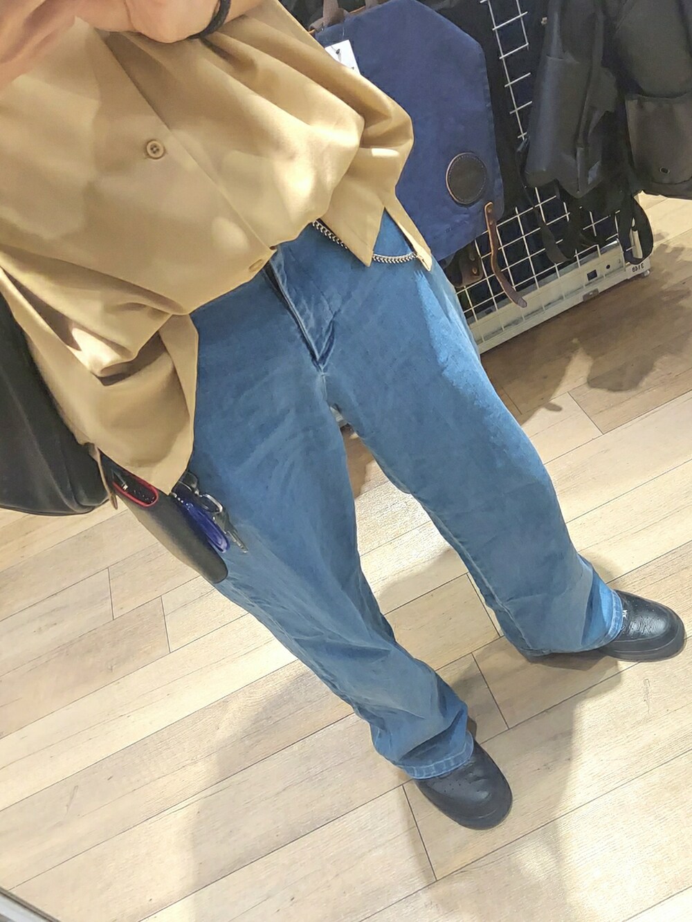 ブルー系のデニムパンツ、ブラック系のスニーカー、ベージュ系のシャツ/ブラウスを着用したメンズの春コーディネートの3枚目の写真