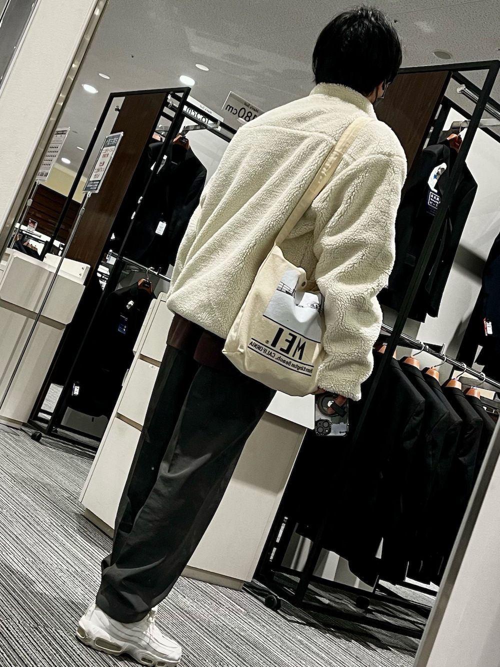 グレー系のスラックス、ホワイト系のスニーカー、ホワイト系のシャツ/ブラウスを着用したメンズの冬コーディネートの2枚目の写真