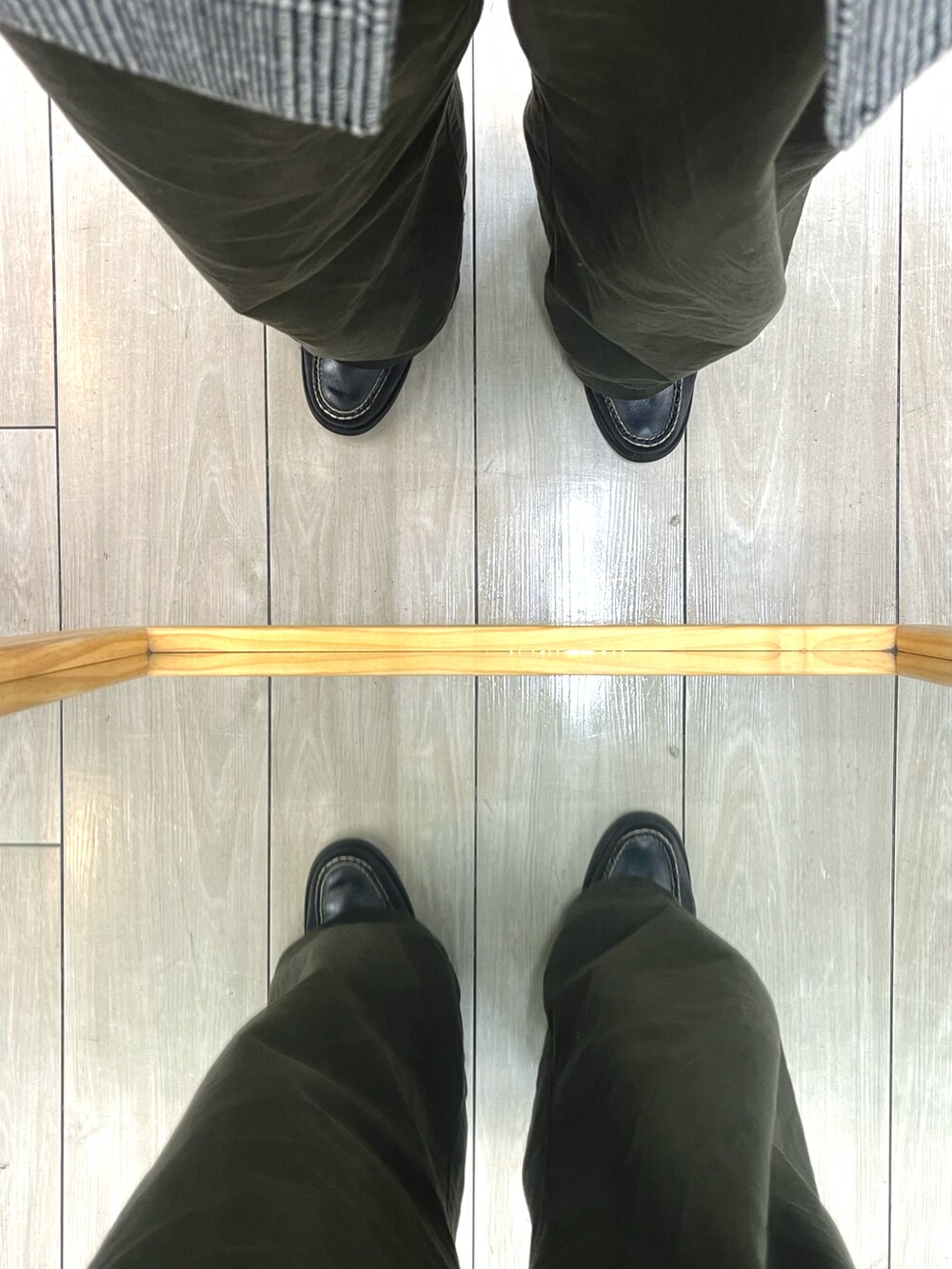 ブラック系のショルダーバッグ、グリーン系のパンツ、ブラック系のローファーを着用したメンズの冬コーディネートの5枚目の写真