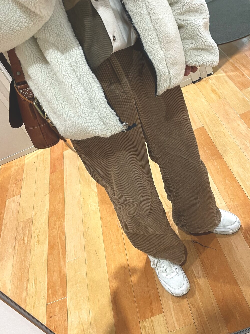 ブラウン系のパンツ、ホワイト系のスニーカー、ブラウン系のボディバッグ/ウエストポーチを着用したメンズの冬コーディネートの3枚目の写真