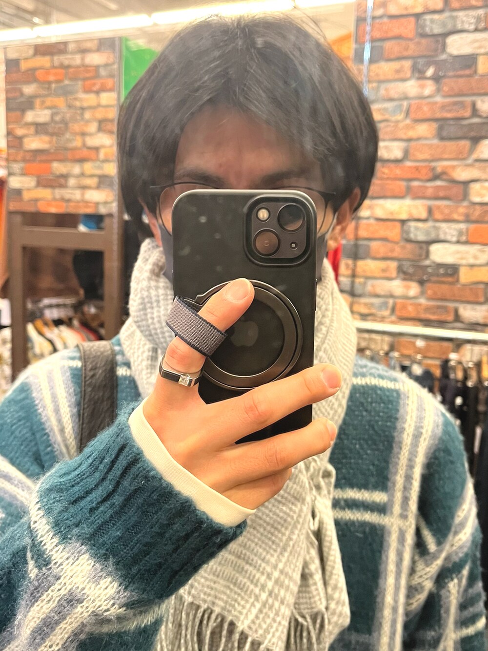 グレー系のパンツ、ブラック系のスニーカー、グリーン系のニット/セーターを着用したメンズの冬コーディネートの4枚目の写真