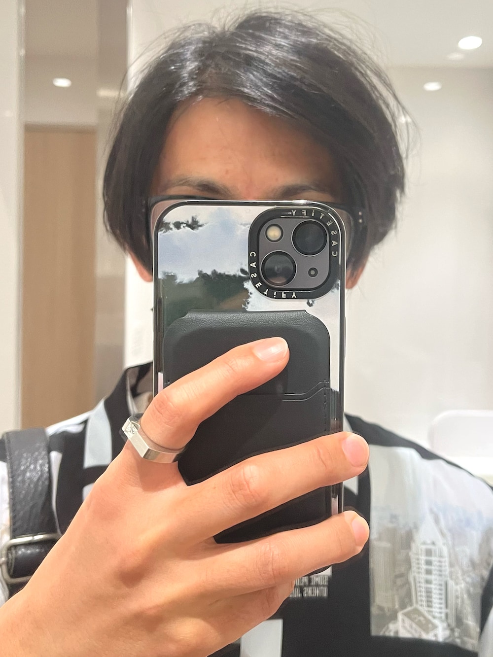 グレー系のスラックス、ブラック系のドレスシューズ、ブラック系のショルダーバッグを着用したメンズの秋コーディネートの4枚目の写真