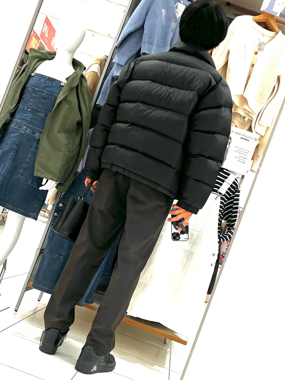 ブラウン系のパンツ、ブラック系のスニーカー、ブラック系のショルダーバッグを着用したメンズの冬コーディネートの2枚目の写真