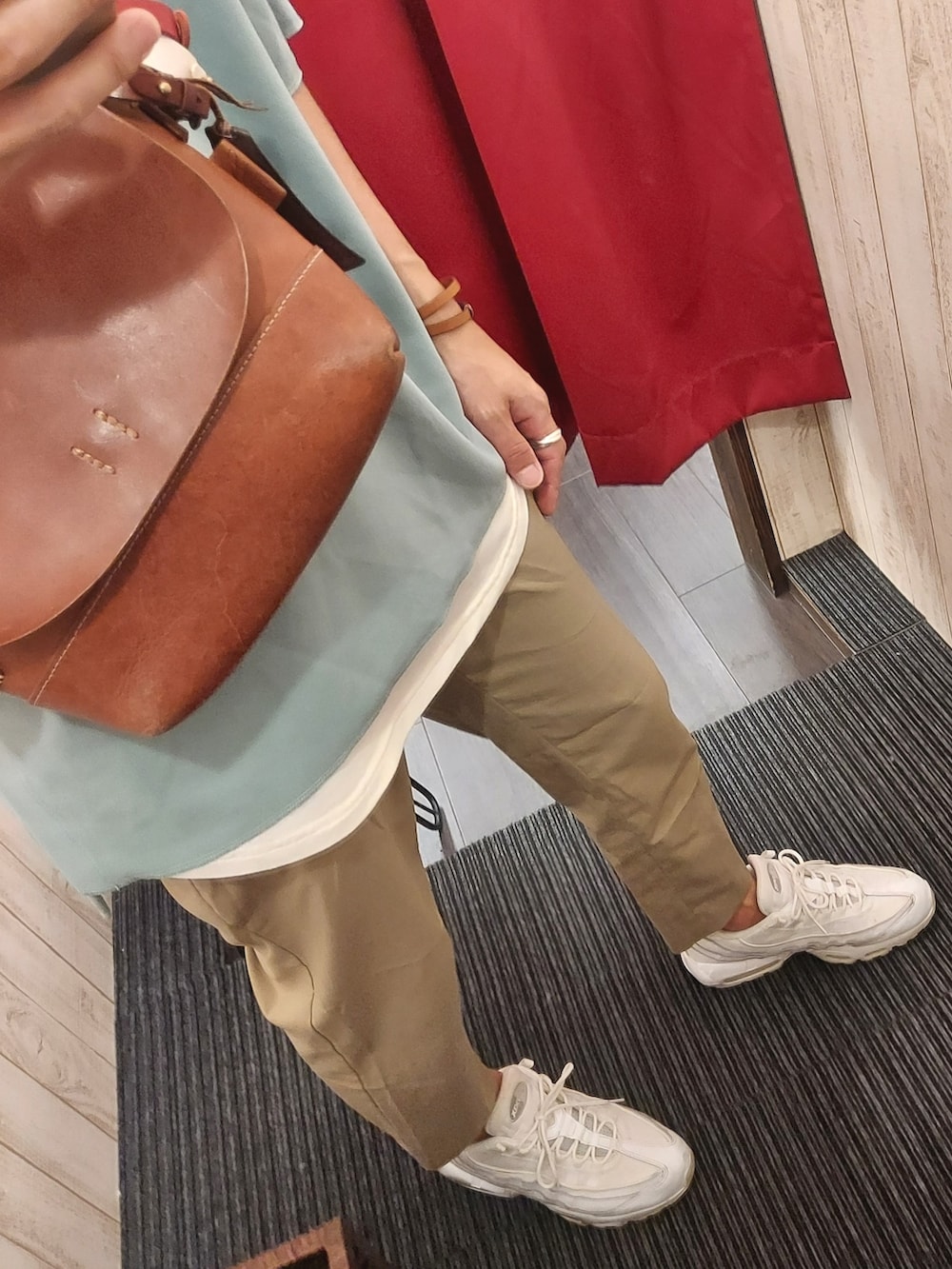 ホワイト系のスニーカー、ベージュ系のスラックス、グリーン系のTシャツ/カットソーを着用したメンズの秋コーディネートの3枚目の写真