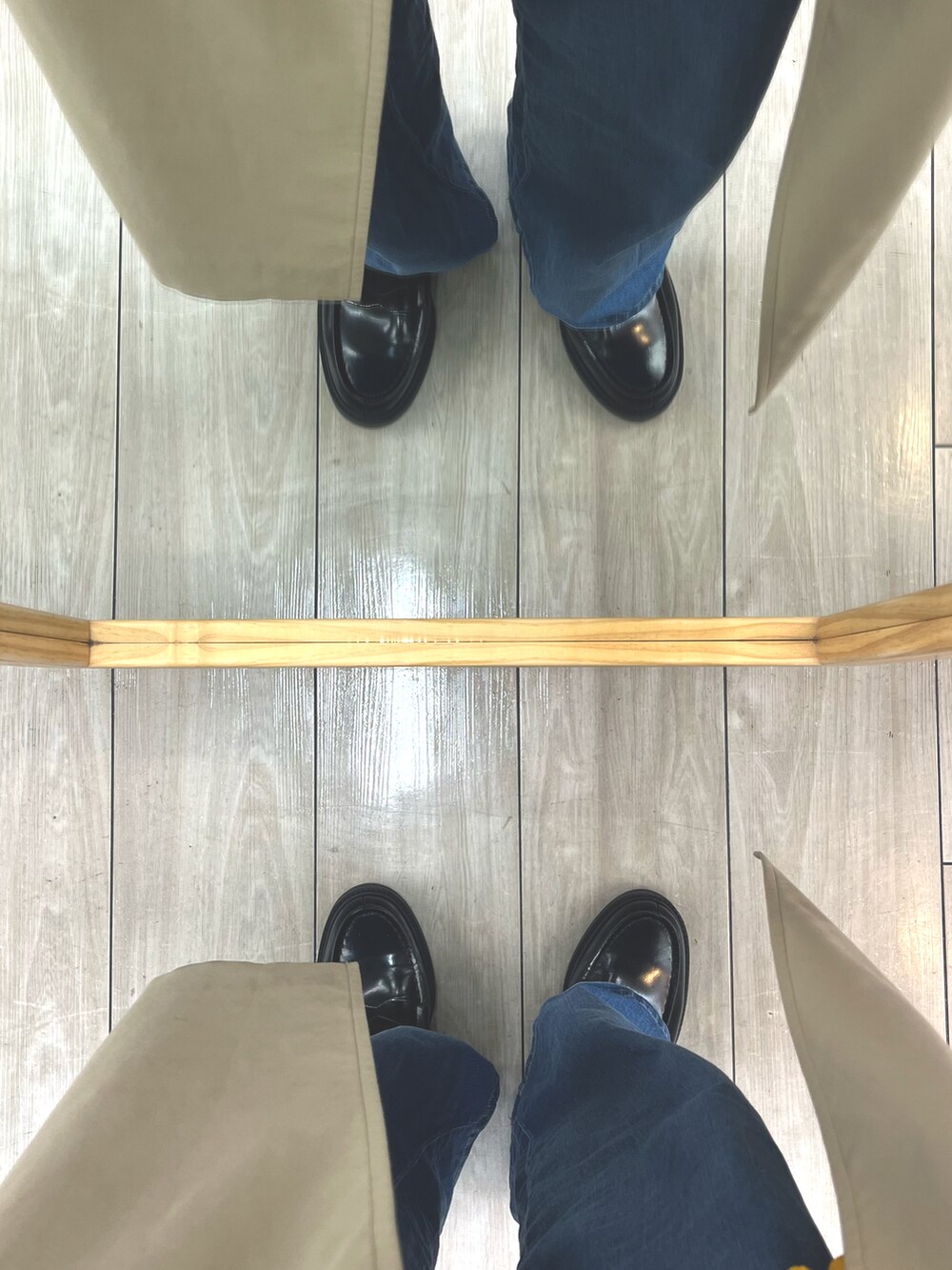 ブラック系のローファー、ブルー系のデニムパンツ、ブラウン系のステンカラーコートを着用したメンズの冬コーディネートの5枚目の写真