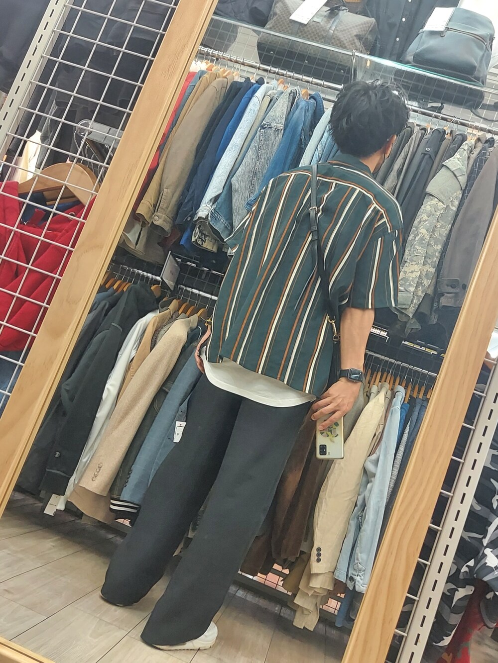 ブラック系のパンツ、ブラック系のバッグ、ホワイト系のタンクトップを着用したメンズの秋コーディネートの2枚目の写真