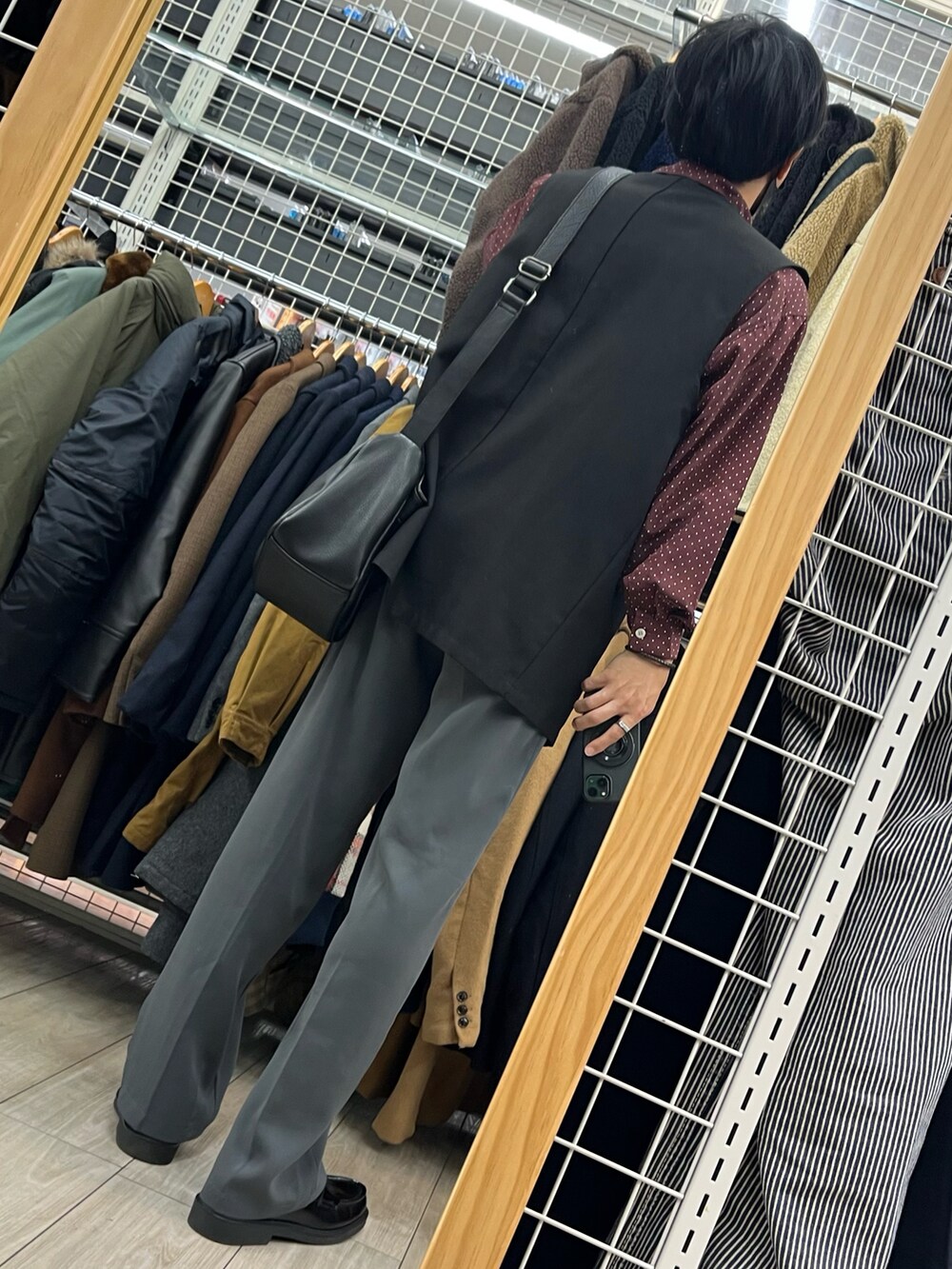 ブルー系のパンツ、ブラック系のローファー、ブラック系のベストを着用したメンズの秋コーディネートの2枚目の写真