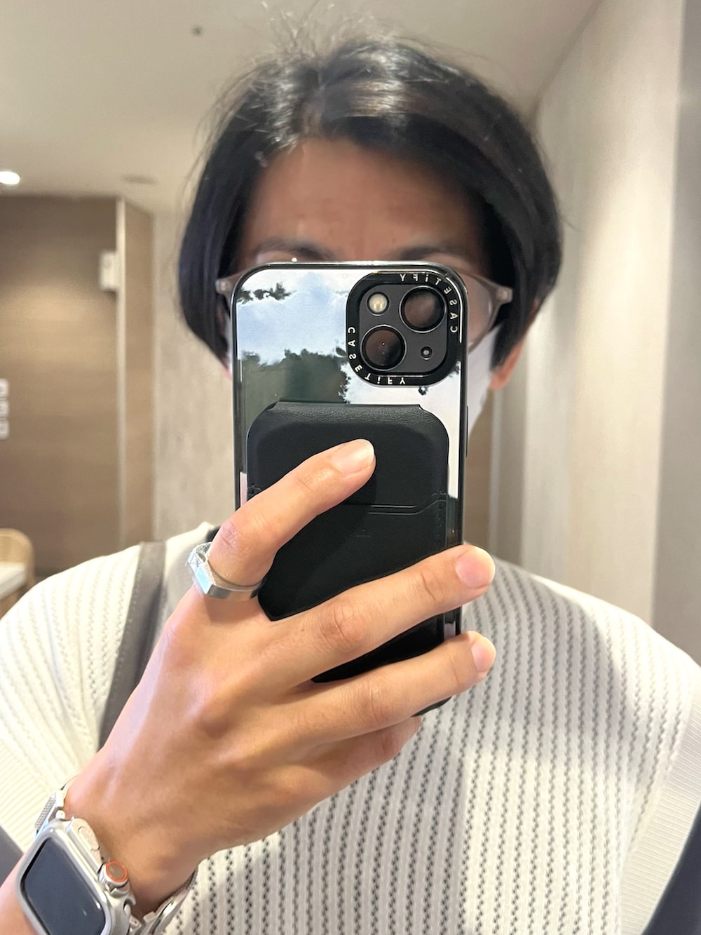 グレー系のスニーカー、ベージュ系のベスト、グレー系のショルダーバッグを着用したメンズの秋コーディネートの4枚目の写真