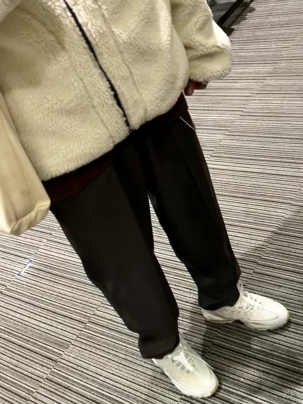 グレー系のスラックス、ホワイト系のスニーカー、ホワイト系のシャツ/ブラウスを着用したメンズの冬コーディネートの3枚目の写真